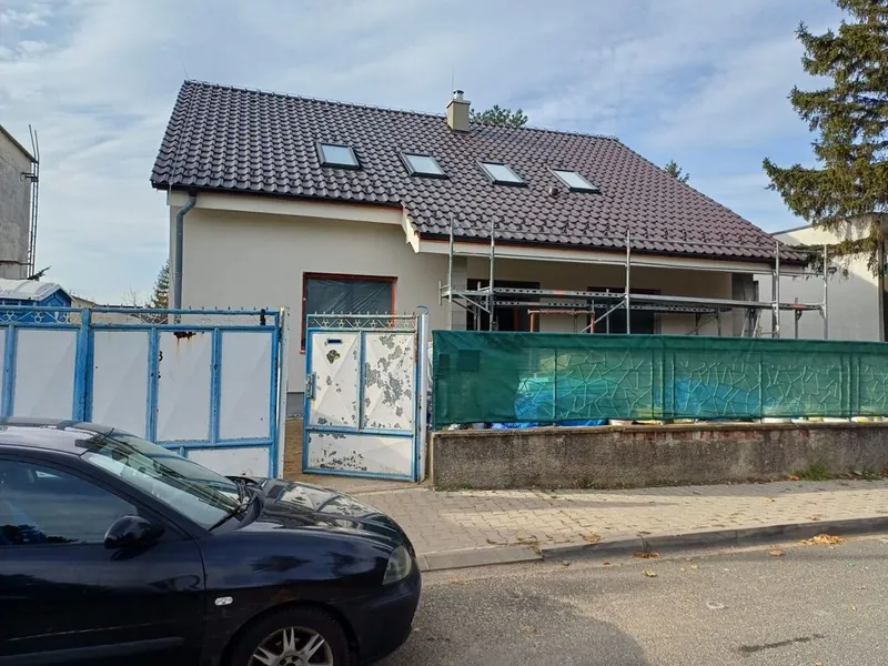 Starší rodinný dom s lešením pred rekonštrukciou strechy a fasády