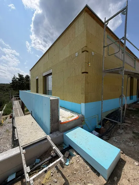 Roh domu so zateplením: modrý XPS na sokli a minerálna vlna na stene